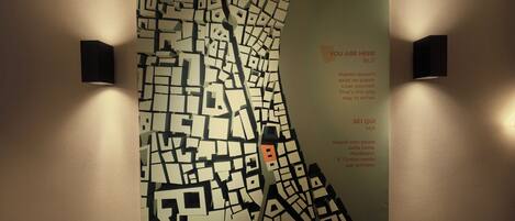 Un mapa colgado en la pared con un lugar resaltado, acompañado por dos lámparas de pared.