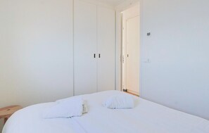 A bedroom with a bed, two pillows, a wooden nightstand, and a white wardrobe. - Earrebarre Houseboat - Overnight stay on the water (Offingawier)