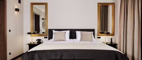 Una habitación de hotel con una cama grande, dos mesitas de noche, un banco y dos espejos amplios.