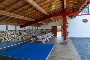 A covered outdoor area with a ping pong table, stone wall, and a wooden ceiling. - Holiday Home “Gîte Ithurrondoa” with Private Pool, Terrace & Wi-Fi (Masparraute)