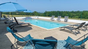 A swimming pool with lounge chairs and umbrellas, surrounded by a fence and greenery. - Holiday Home “Gîte Ithurrondoa” with Private Pool, Terrace & Wi-Fi (Masparraute)
