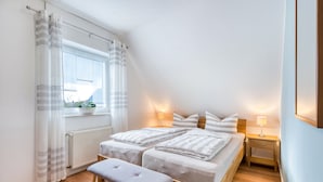 Makuuhuoneessa on suuri ikkuna, kaksi sänkyä, penkki, yöpöytävalaisimet ja patteri.