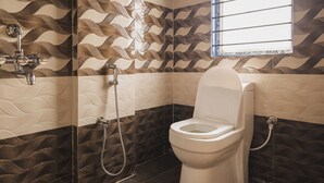 A bathroom with a toilet, shower, and a window. - Lotus Leaf Guest House (Guwahati)