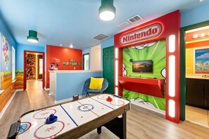 A Nintendo-themed room with a play area, a Nintendo logo, and a television. - Private Pool Oasis, Solara Resort,  Stylish Decor (Four Corners)