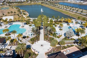 Ein Resort mit mehreren Schwimmbecken, Palmen und einer Springbrunnenanlage.