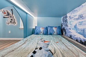 A bedroom with a bed featuring a snowman design, a wall-mounted light fixture, and a large window with blinds. - Private Pool Oasis, Solara Resort,  Stylish Decor (Four Corners)