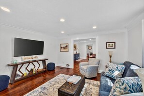 A living room with a flat-screen TV, a coffee table, a sofa, and a patterned rug. - 2 bedrooms king/queen, sofa bed, fenced yard (Aiken)