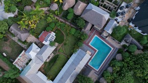 An aerial view of a resort with a swimming pool, multiple buildings, and surrounding greenery. - APAO VILLAGE & RESORT LODGE (Dar es Salaam)
