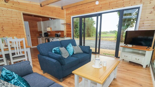 Un intérieur de chalet chaleureux avec un canapé, une table basse et un coin télévision.