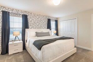 A bedroom with a bed, nightstands, a lamp, and a window with curtains. - Beautiful Storey Lake Retreat, Minutes from Disney (Kissimmee)