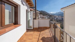 A balcony with a view of a town and mountains.