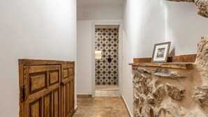 Un pasillo con una puerta de madera, una pared de piedra y una pared de baldosas con un diseño de estrellas.