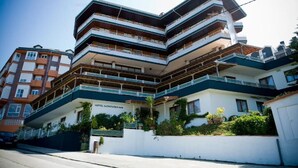 A multi-story hotel with balconies, a white facade, and a sign reading "HOTEL MONTANES". - Hotel Montañes (Suances)