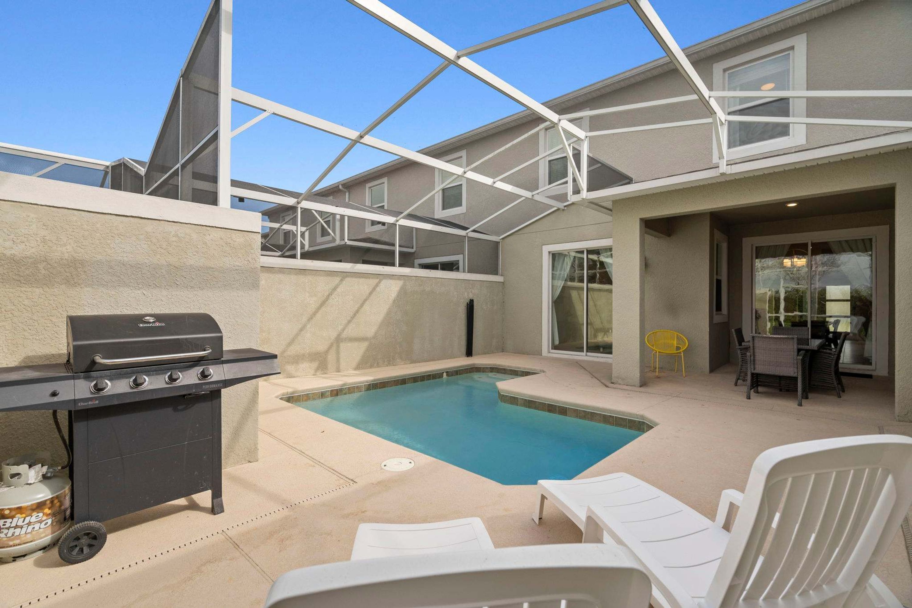 Ein Garten mit Pool, Grill und Gartenmöbeln.