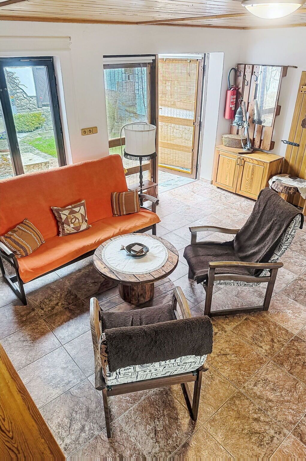 A cozy living room with a sofa, two armchairs, a coffee table, and a fireplace.