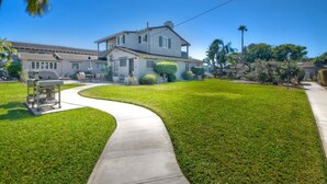 A two-story house with a curved driveway, a lawn, and a clear blue sky. - 90 Walk Score l Private Patio | Steps to Beach & Dining | Parking (Carlsbad)