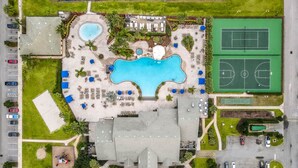 An aerial view of a resort with a large swimming pool, tennis courts, and a parking area. - Lovely House for 10 People at Paradise (Four Corners)