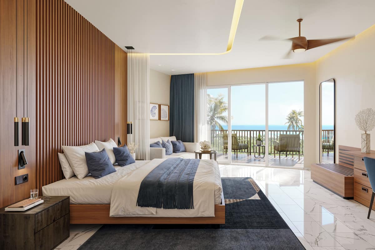 Habitación de hotel moderna con una cama grande, un escritorio, un balcón con vista al océano y un ventilador de techo.