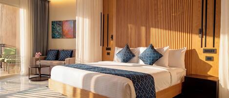A modern hotel room with a large bed, a wooden headboard, and a view of the outdoors.