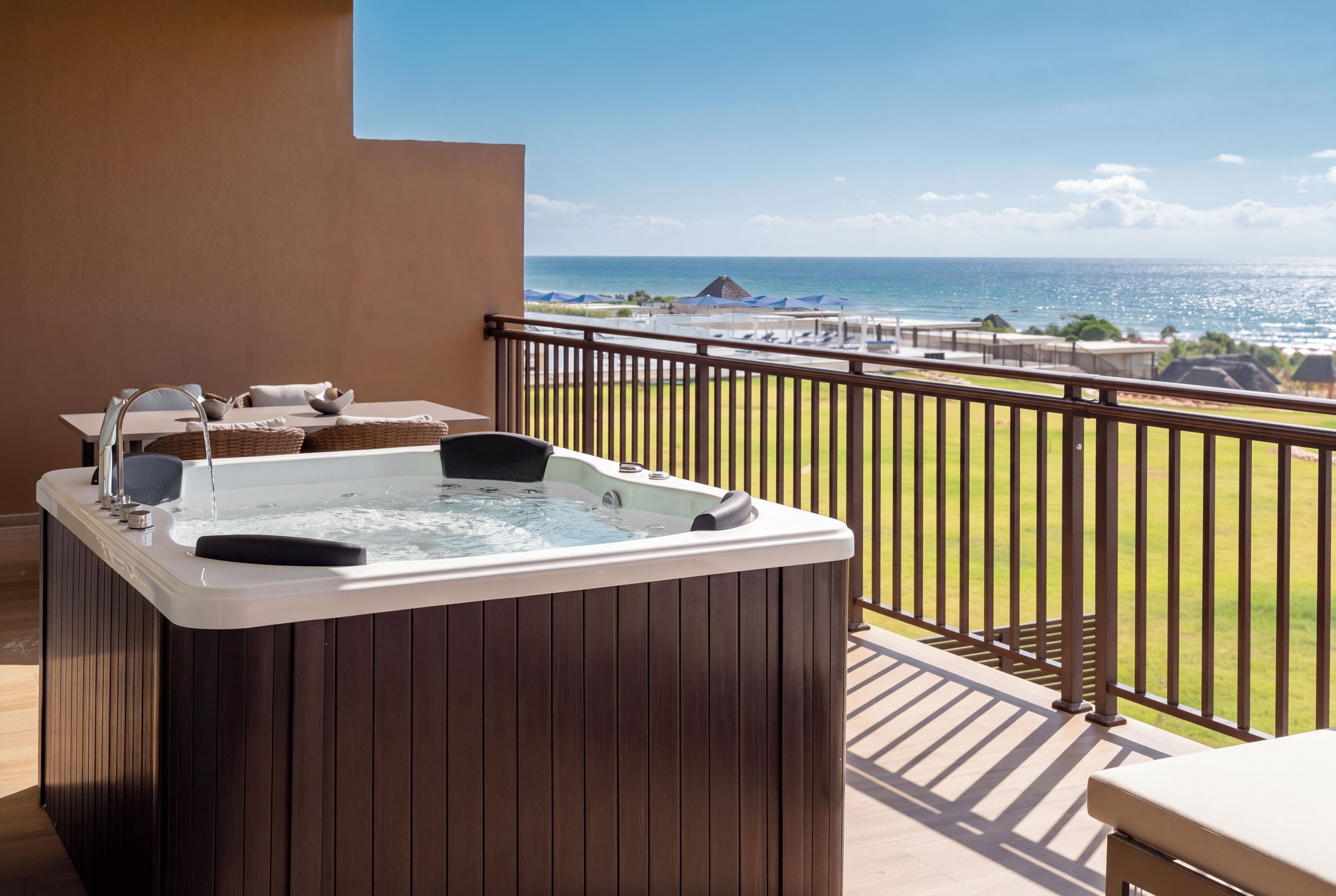 A hot tub on a balcony with a view of the ocean.