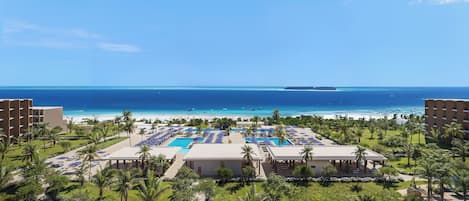 A resort with a pool area, beach, and ocean view.