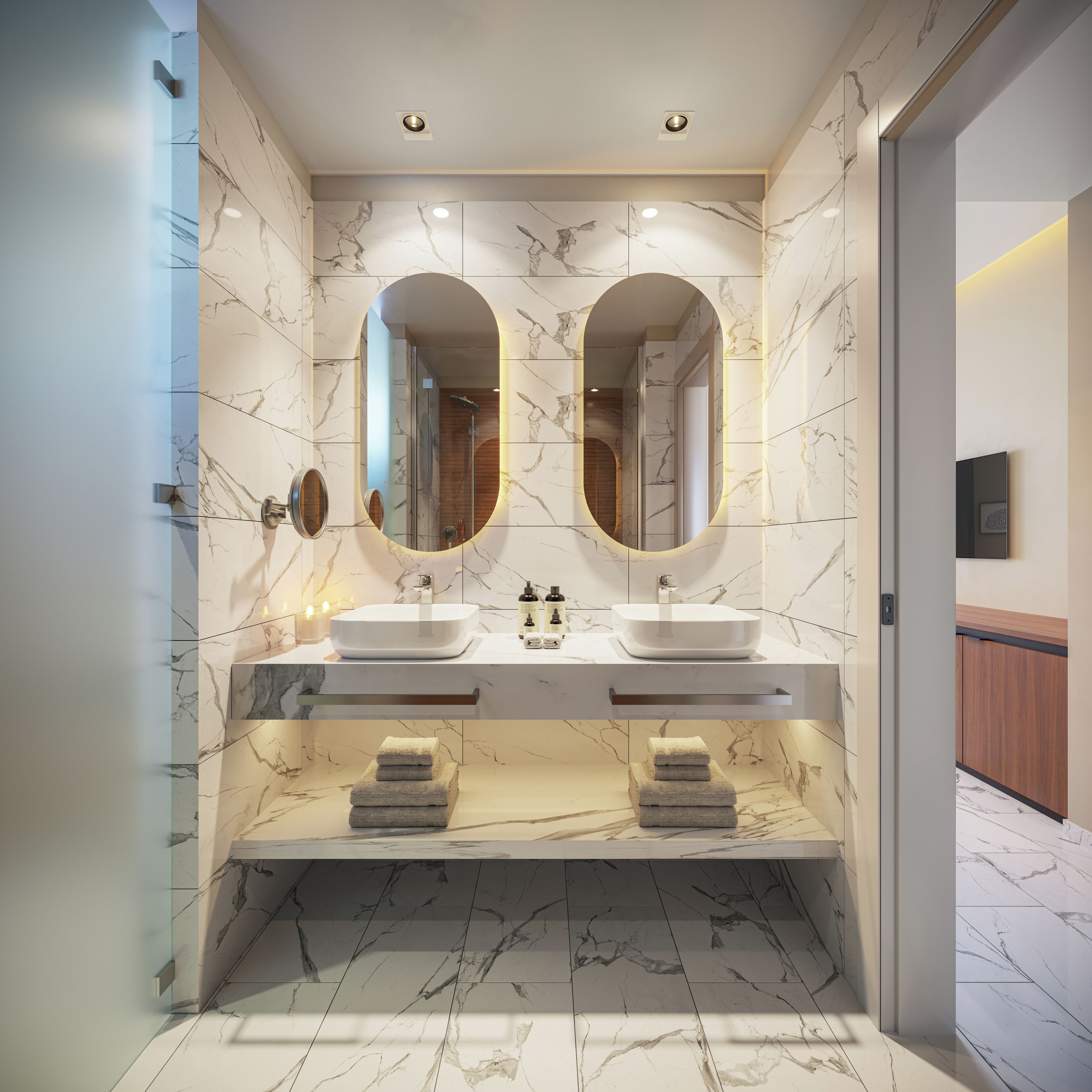 Un baño moderno con dos lavamanos, paredes de mármol y un espejo grande.