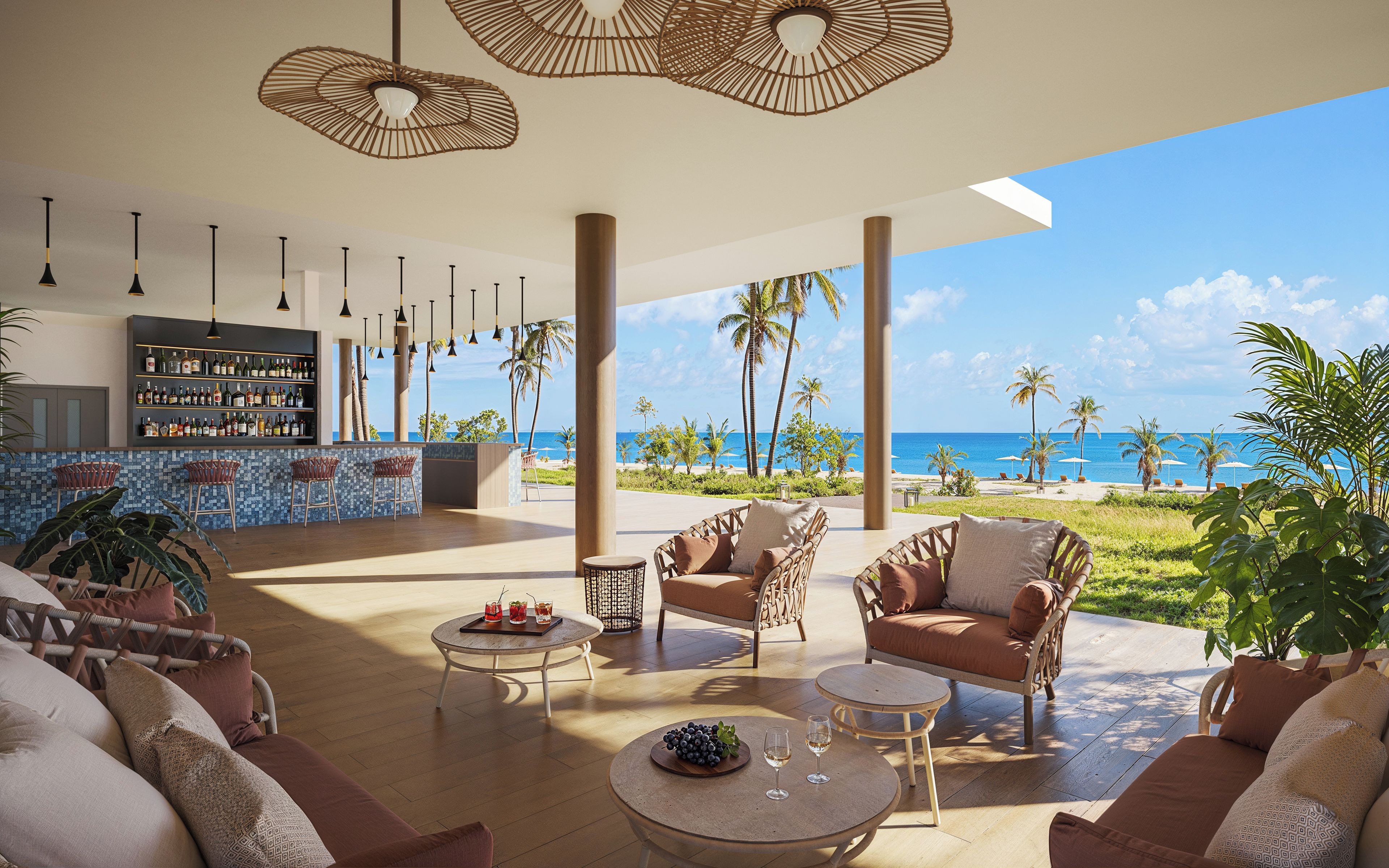 A spacious outdoor lounge area with a bar, comfortable seating, and a view of the beach.