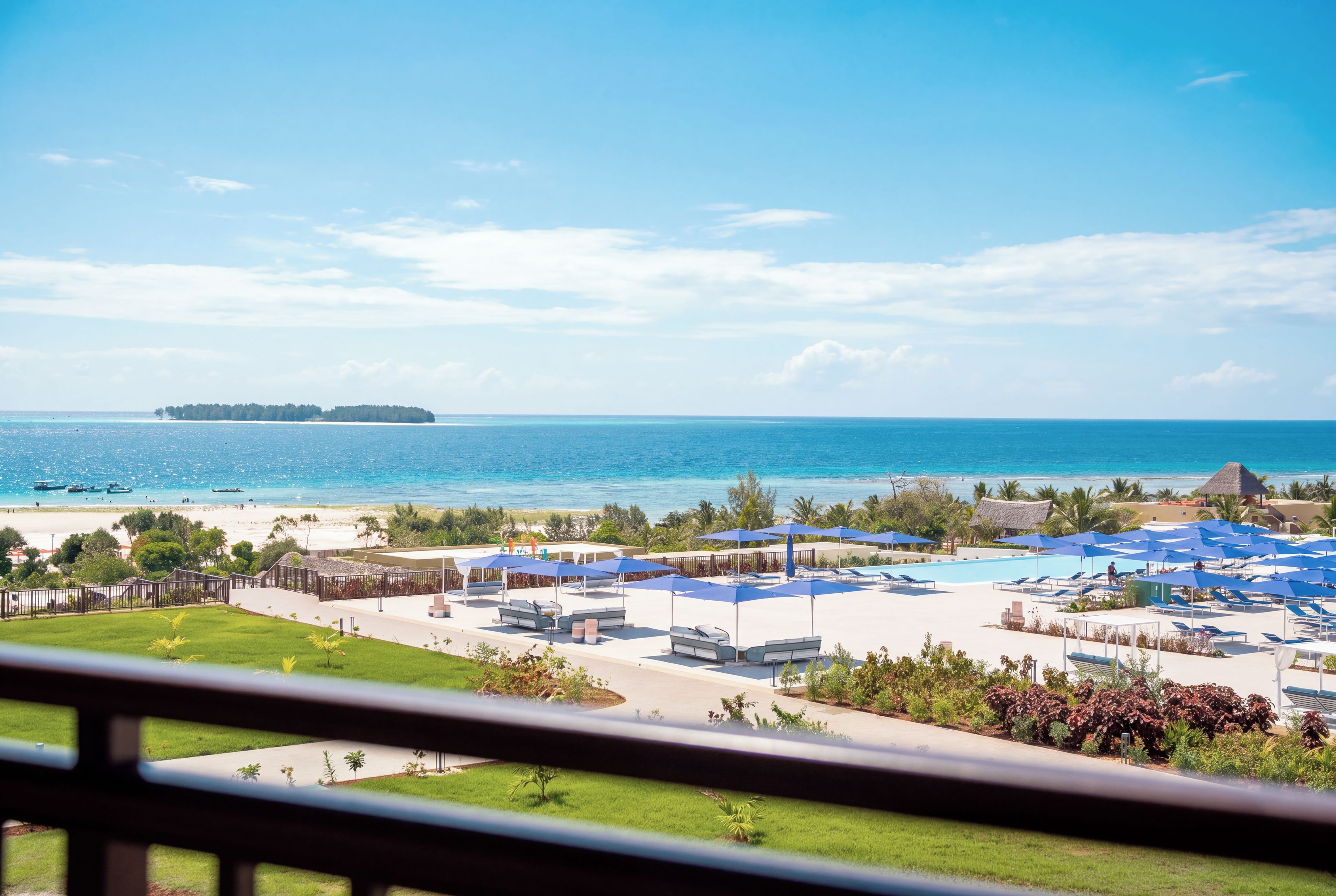 Un resort con zona de piscina, sillas de descanso y vistas al océano.