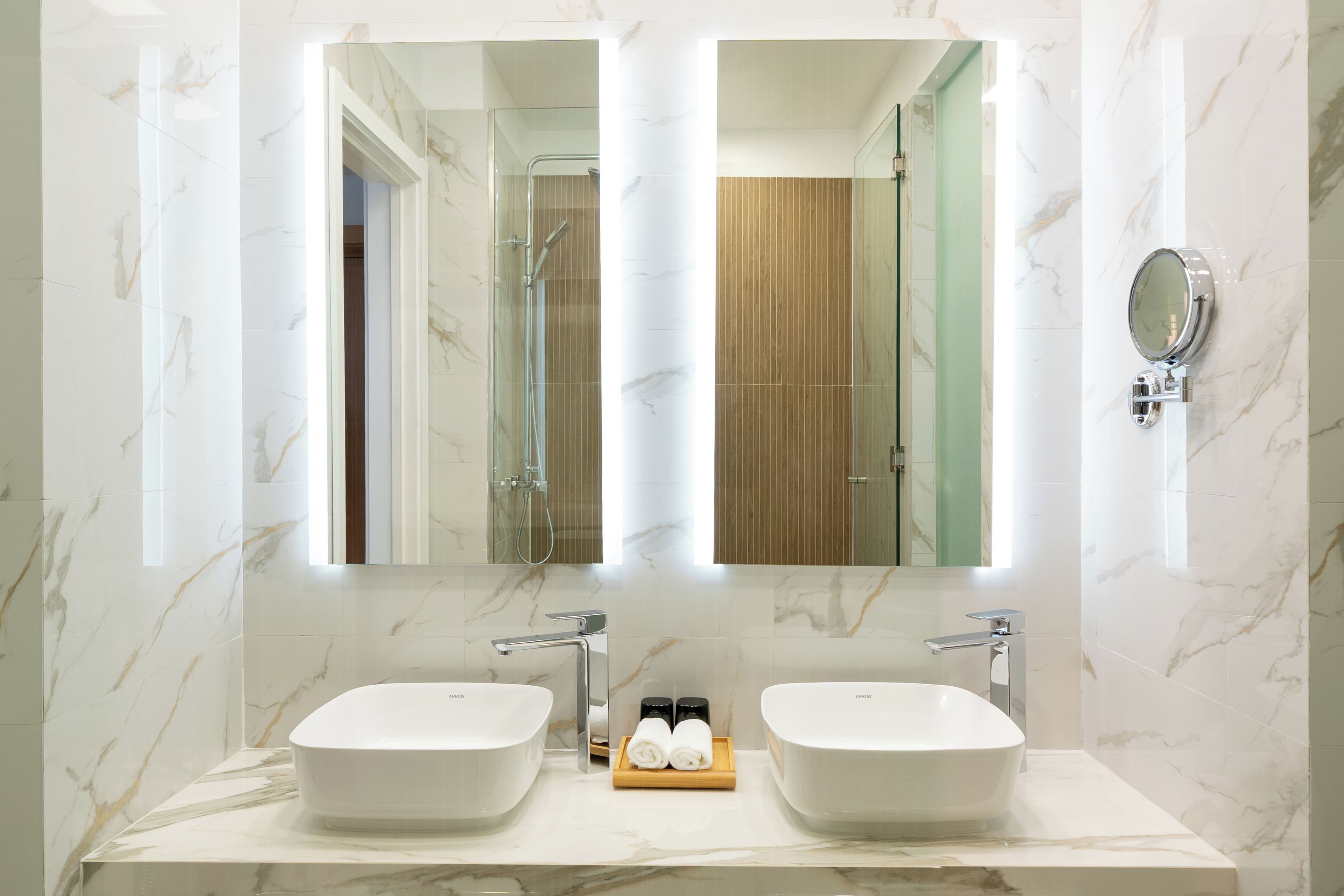 Un baño con dos lavamanos, un espejo y una ducha.