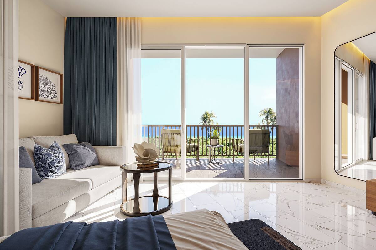 Una habitación de hotel moderna con balcón, sofá, una mesa redonda y un espejo grande.
