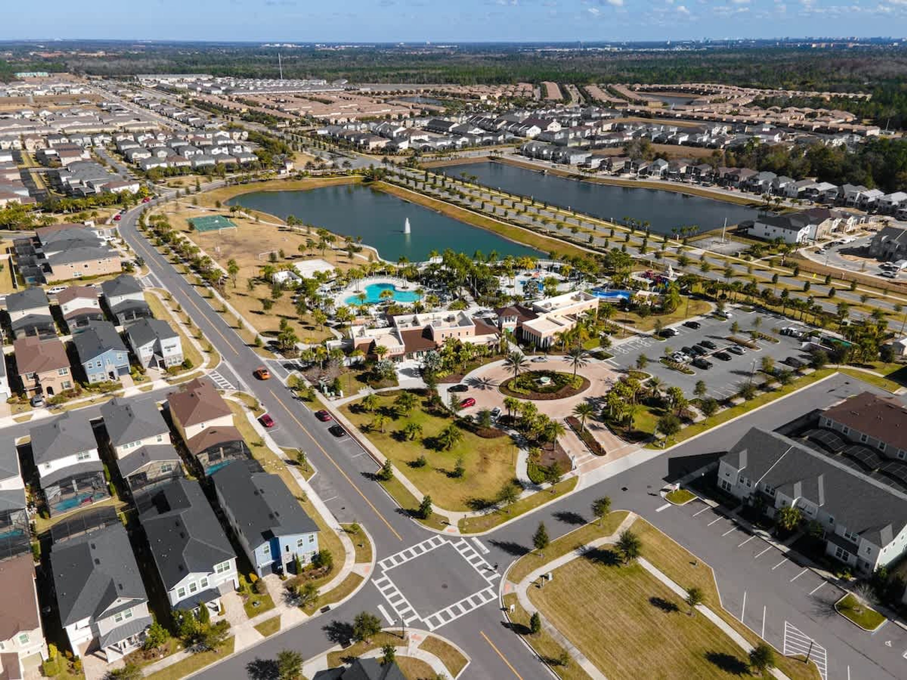 Vista aèria d'una zona residencial amb un gran parc central, una piscina i nombroses unitats d'habitatge.