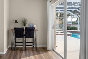 A room with a pool view, two chairs, a lamp, and a small table with a plant. - New Listing ! Pool and Game Room 4BR (Four Corners)