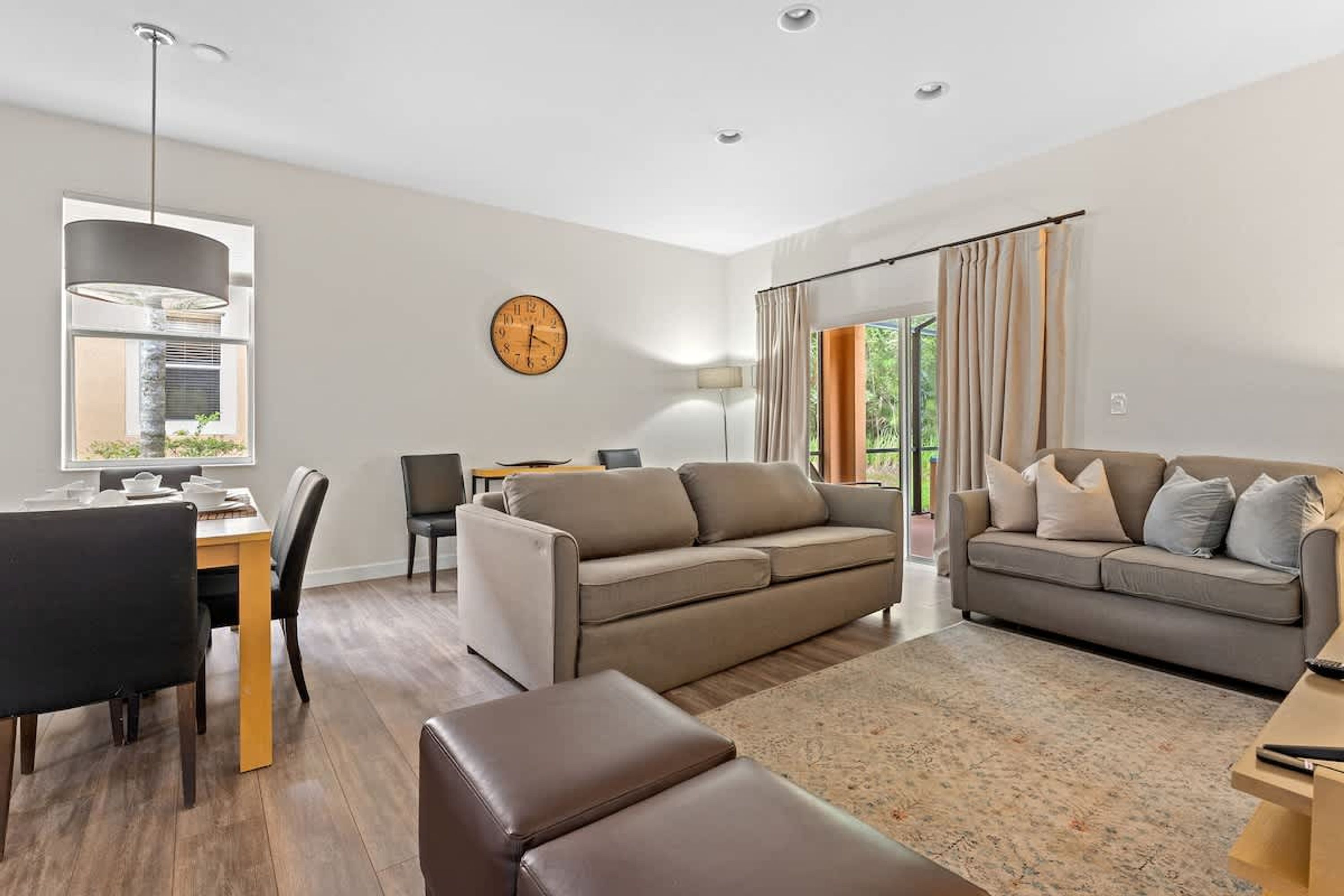 Een moderne woonkamer met een bank, een eettafel en een lamp.