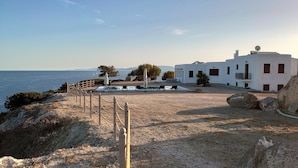 Una proprietà costiera con piscina, area salotto esterna e vista mare.