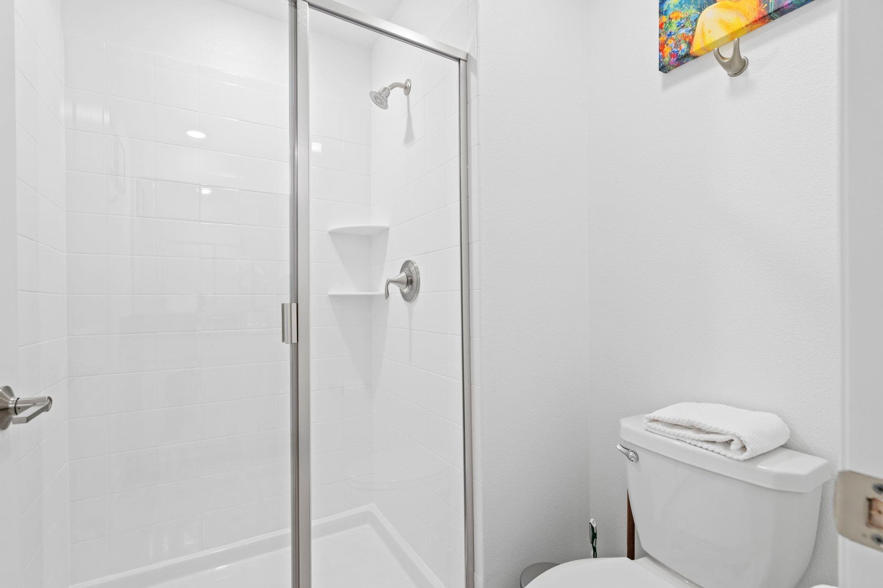 Ein Badezimmer mit Duschkabine, Toilette und Handtuchhalter.