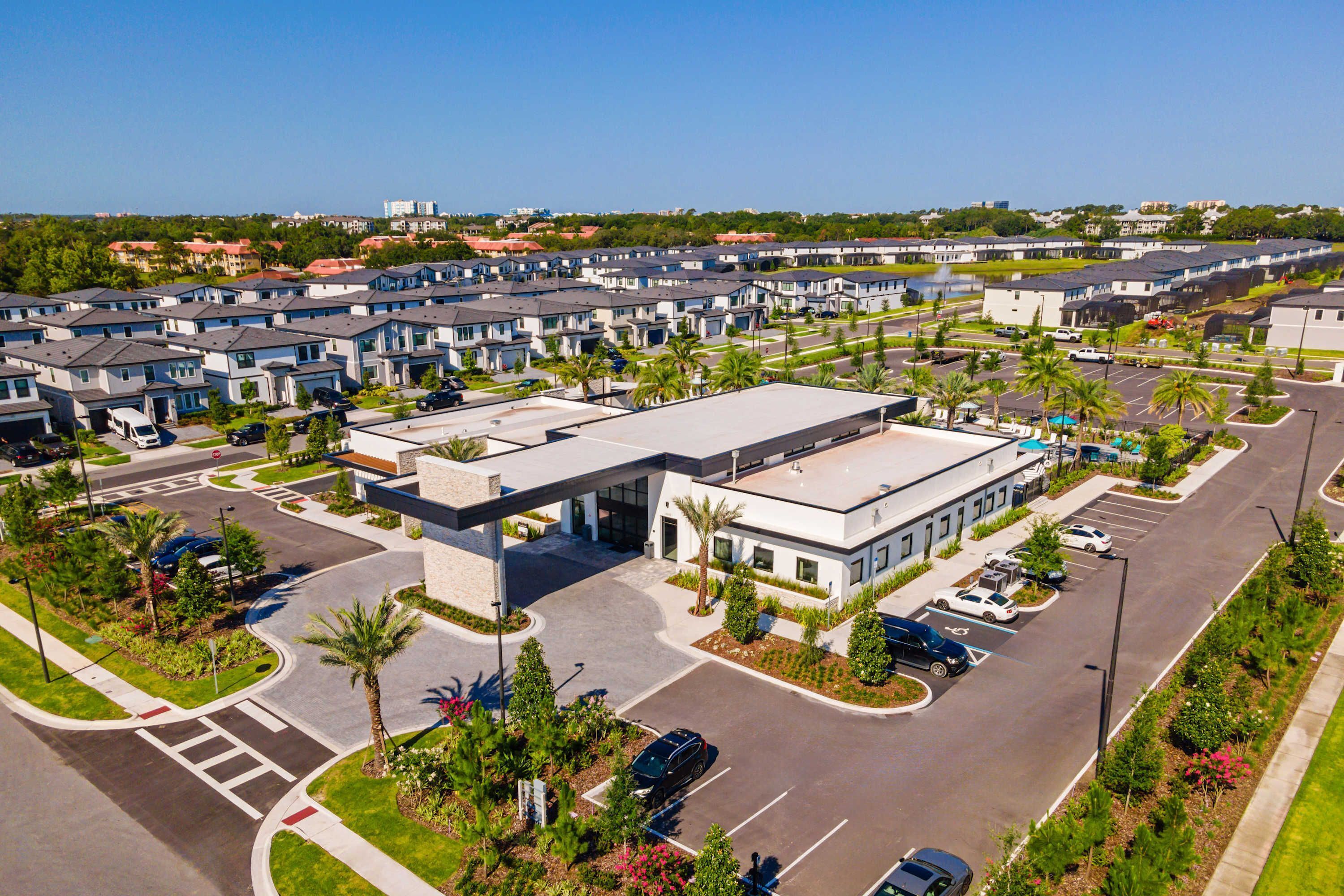 Un complexe résidentiel moderne comprenant plusieurs immeubles d’appartements, un parking central et des jardins aménagés.