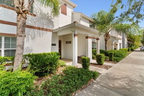 A row of modern residential buildings with a white facade, brown trim, and a number '3197' visible. - 4BR Townhome with Pool at Storey Lake (Kissimmee)