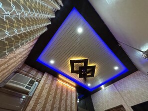A ceiling with recessed lighting and a geometric light fixture. - Urban Lake Stay (Varanasi)