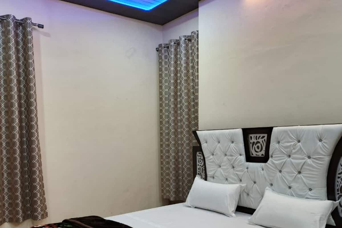 Ein Schlafzimmer mit Bett, Vorhängen, Deckenventilator und einer Lampe.