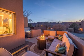 An outdoor seating area with a fire pit, cushioned seating, and a view of the surrounding landscape. - New Listing! Red Rock Retreat | Hot Tub & Fire Pit | Kings in Every Room (Moab)