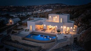 Una vila moderna amb piscina, mobiliari d'exterior i vistes al paisatge circumdant.