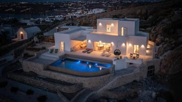 Une villa moderne dotée d’une piscine, d’un espace extérieur aménagé et offrant une vue sur le paysage environnant.
