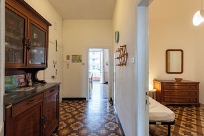 A hallway with a wooden cabinet, a bed, and a dresser.