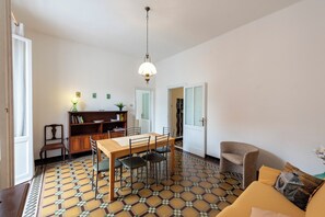 Un coin repas avec une table et des chaises, une bibliothèque et un luminaire suspendu.
