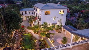 A two-story building with a garden, a pond, and a covered walkway. - Sol Flow Retreat (Hoa Lu)