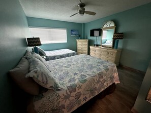 A bedroom with two beds, a ceiling fan, a dresser, and a window with blinds. - Beach   Pool Open  Direct Beachfront Condo  Sunsets (Siesta Key)