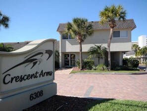 A building with a sign reading "Crescent Arms 6308" and palm trees in the foreground. - Beach   Pool Open  Beachfront View Every Room (Siesta Key)