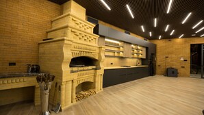 Une cuisine moderne dotée d’un four en briques, de planchers en bois et d’un bar intégré.