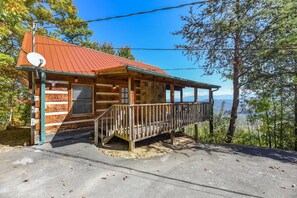 A cabin with a metal roof, wooden exterior, and a porch with a railing. - View  Private Studio Cabin Hot Tub RELAX Honeymoon (Sevierville)