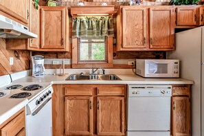 A kitchen with wooden cabinets, a stove, a microwave, and a dishwasher. - View  Private Studio Cabin Hot Tub RELAX Honeymoon (Sevierville)